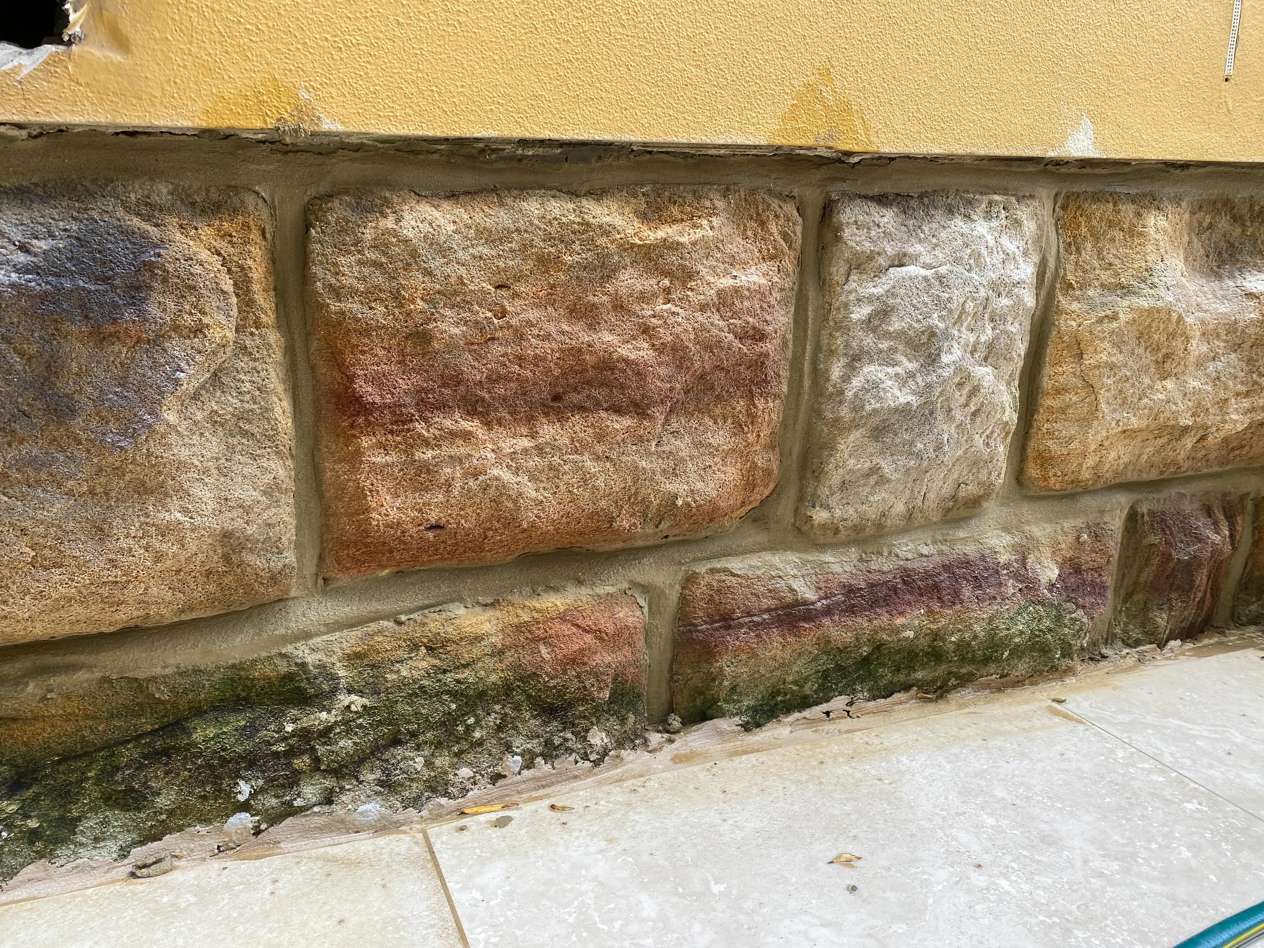Heritage sandstone wall close-up with fresh pale mortar between blocks after repointing