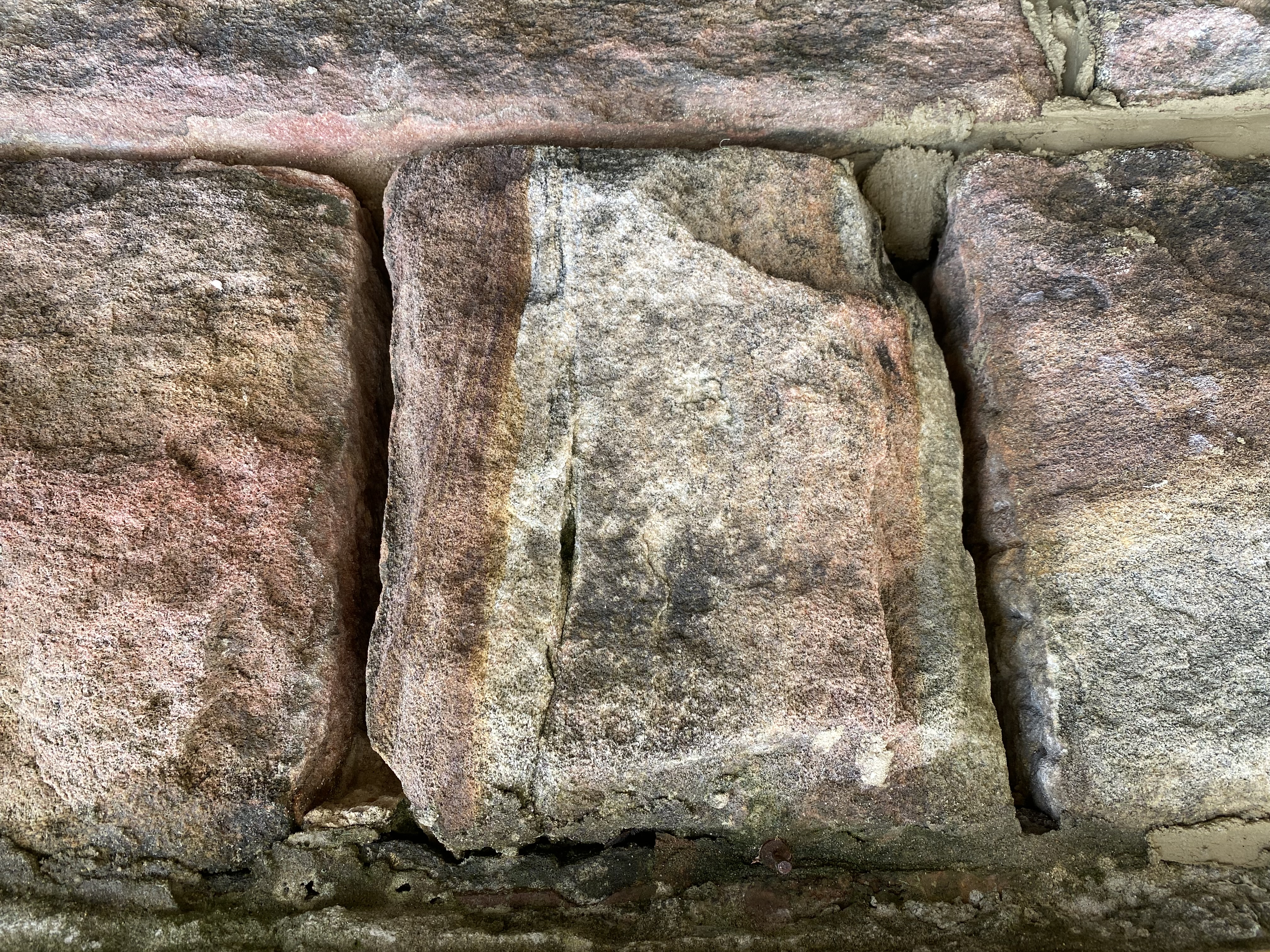 Close-up of weathered sandstone block with deep vertical crack before remedial repointing
