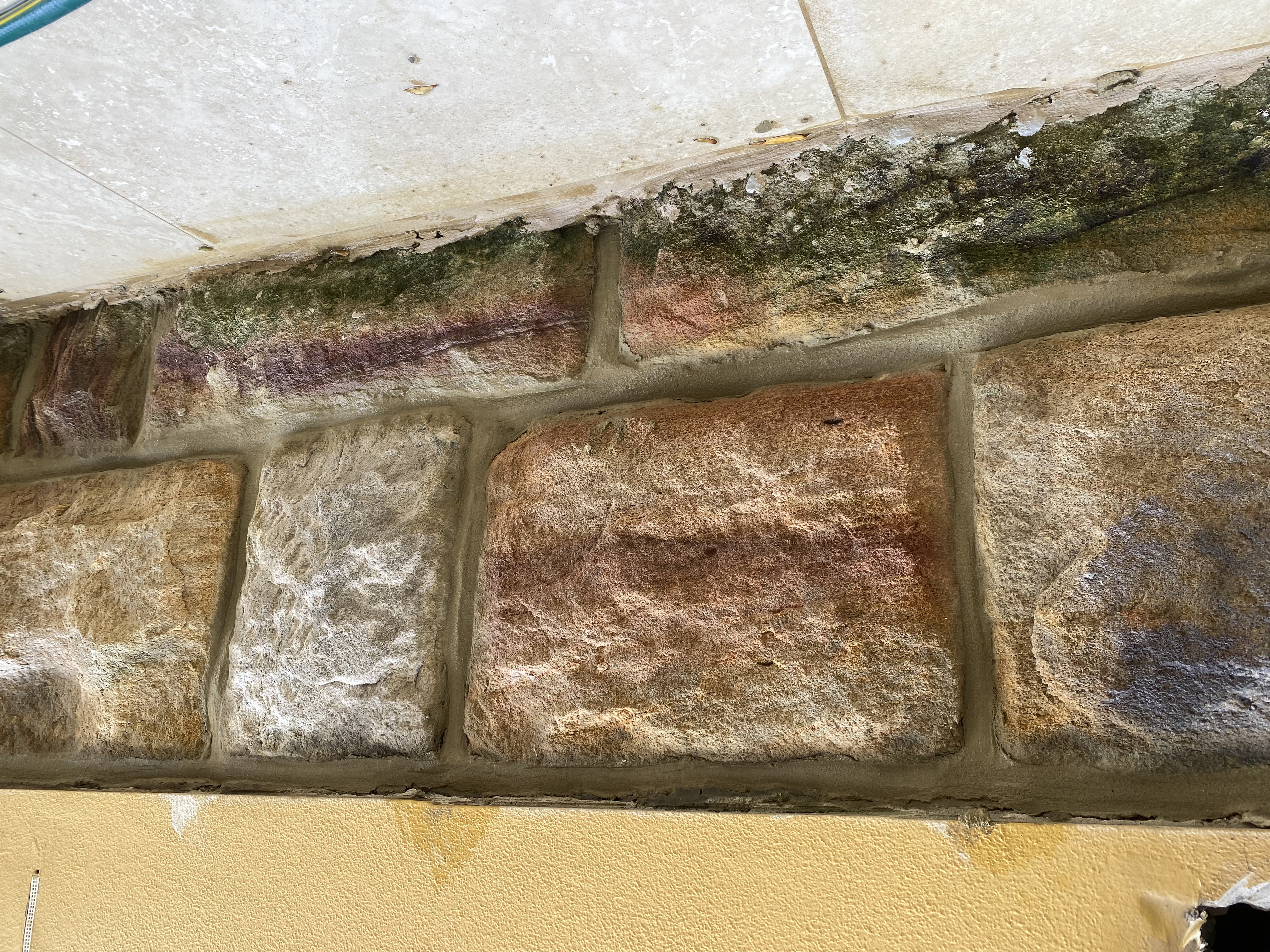 Heritage sandstone wall close-up with fresh pale mortar between blocks after repointing