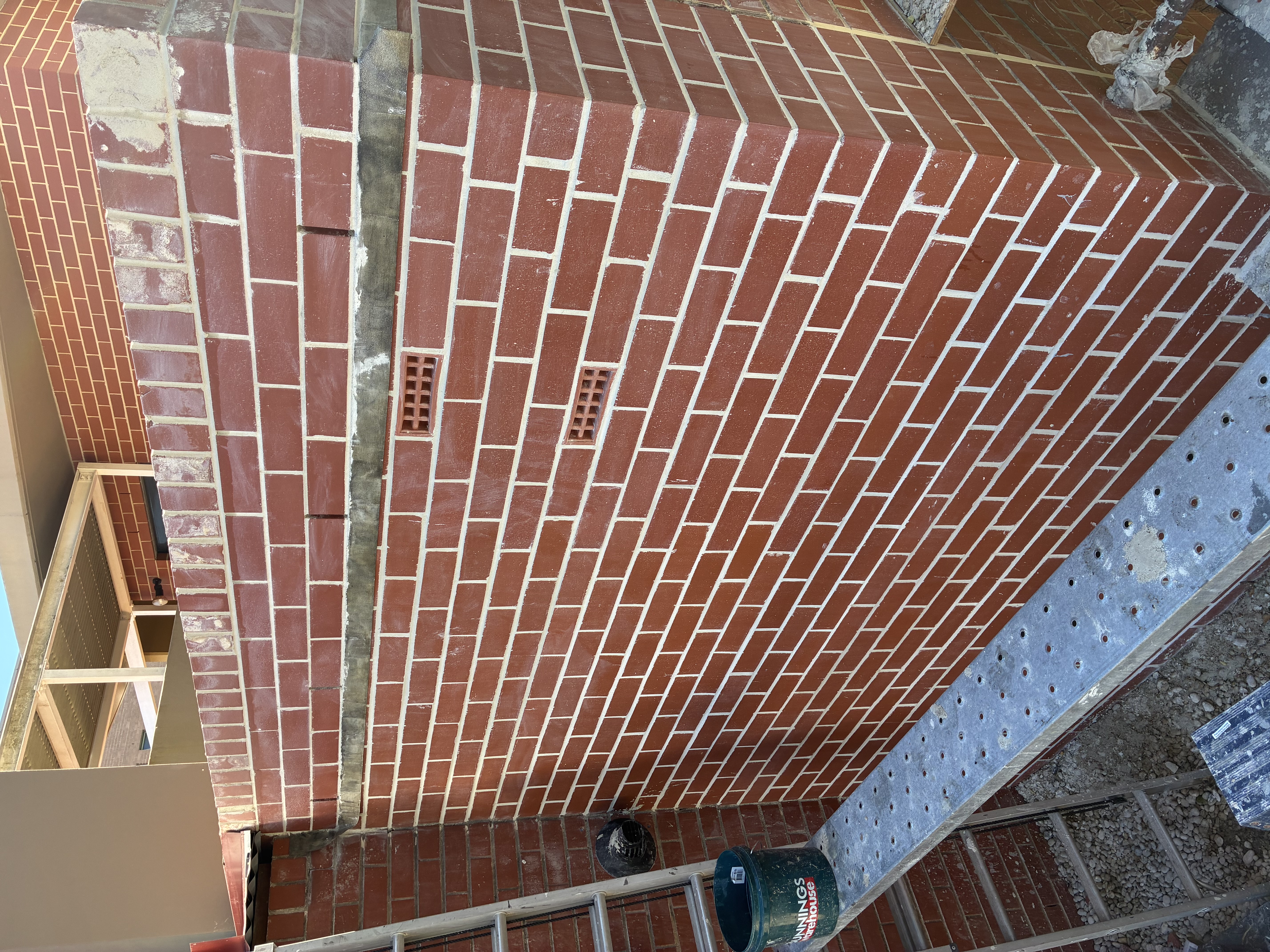 Full wall section with fretting bricks replaced in matched red brick, vents and fresh mortar visible