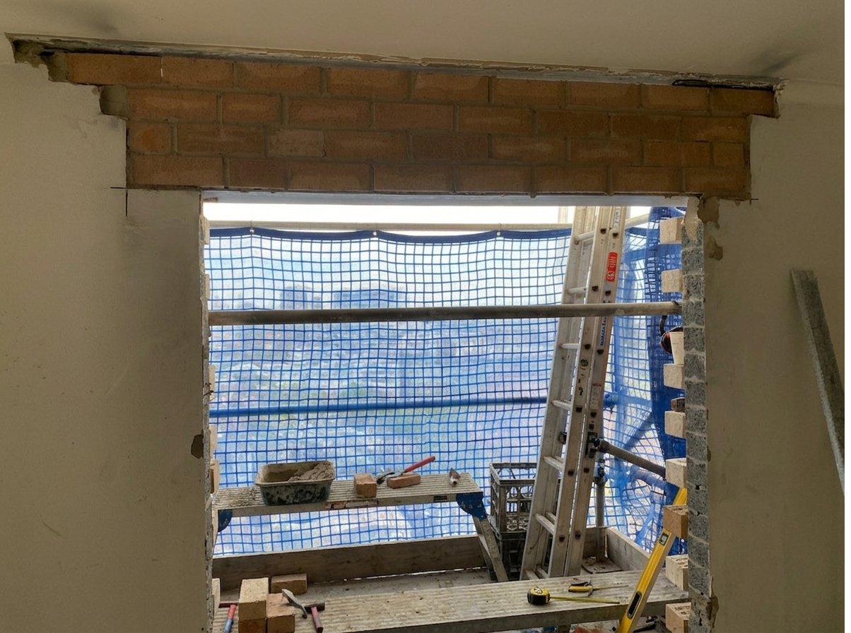 View through internal opening with new lintel above and replacement soldier course bricks set on temporary props